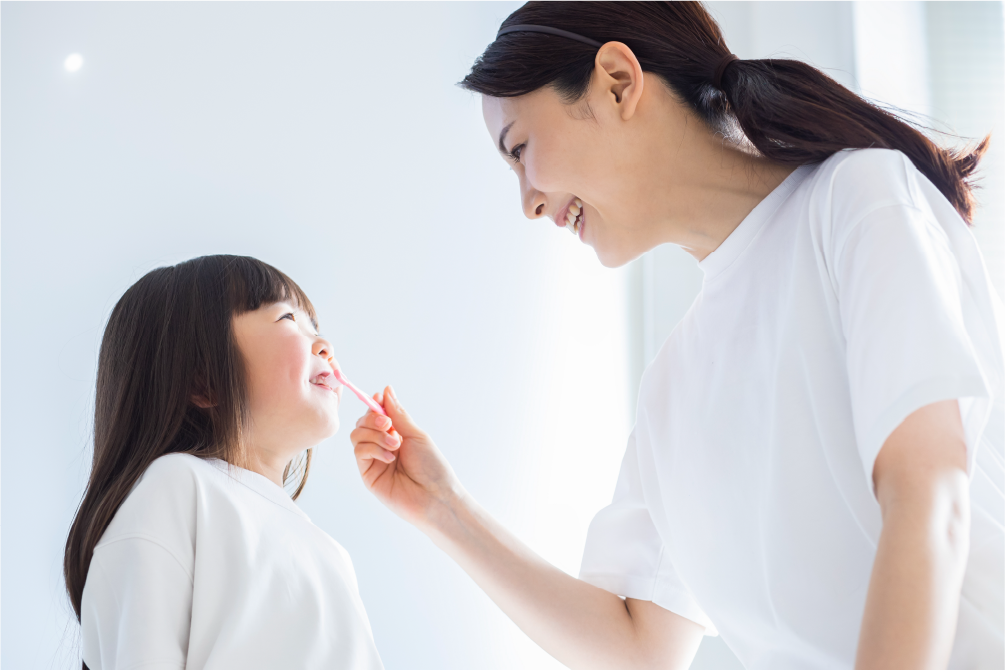 子どもの仕上げ磨きをする母親